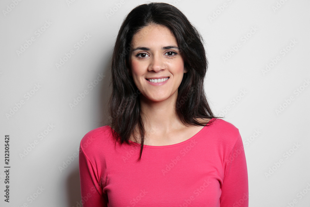 Attractive young woman posing on light background Attractive young woman posing on light background