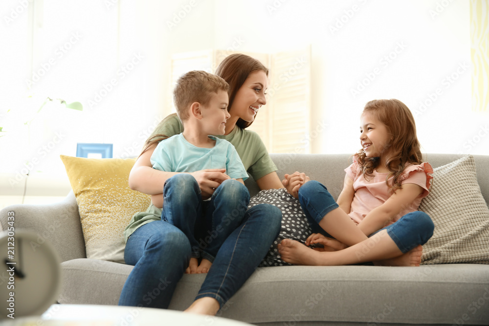 Young woman spending time with her children at home. Happy family