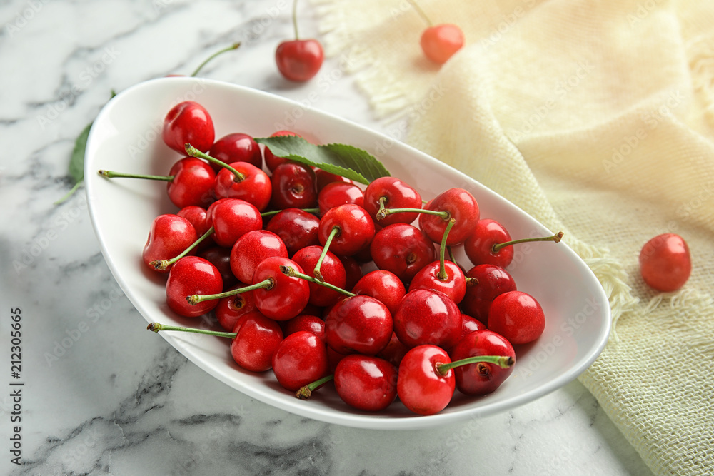Bowl with sweet red cherries on marble table Bowl with sweet red cherries on marble table