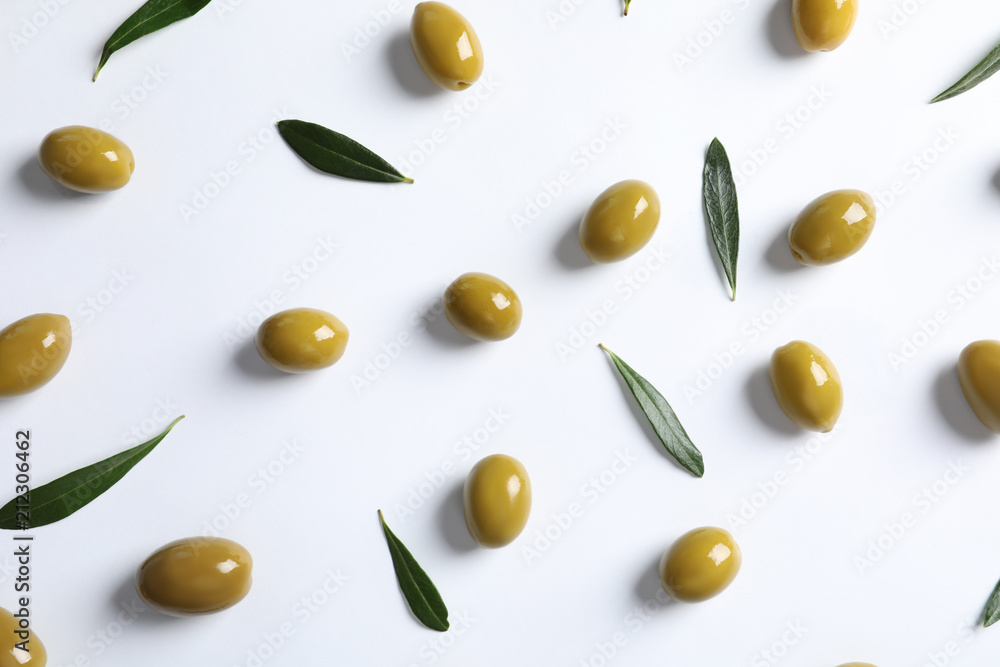 Flat lay composition with fresh olives covered with oil on white background