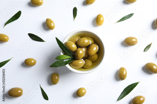 Flat lay composition with fresh olives in oil on white background