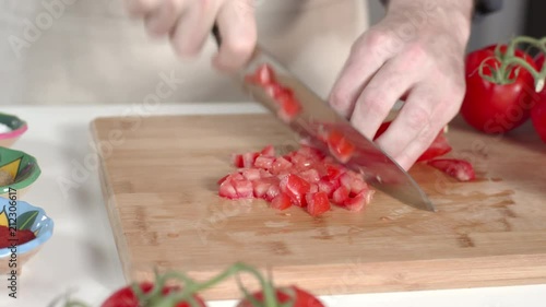 Dolly shot of chef dicing ripe tomato and transferring to large white bowl