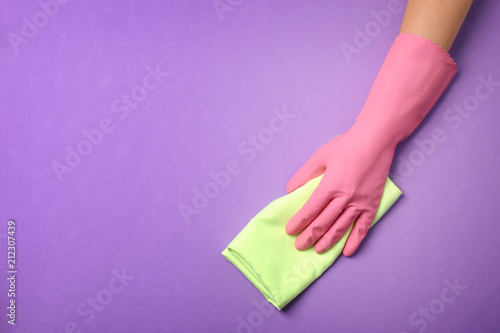 Woman holding rag on color background. Cleaning service
