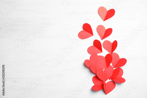 Small paper hearts on wooden background, top view