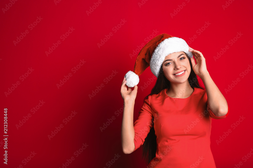 Young beautiful woman in Santa hat on color background. Christmas celebration Young beautiful woman in Santa hat on color background. Christmas celebration