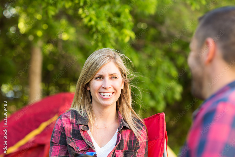 Fototapeta premium Couple talking and laughing on a camping trip.