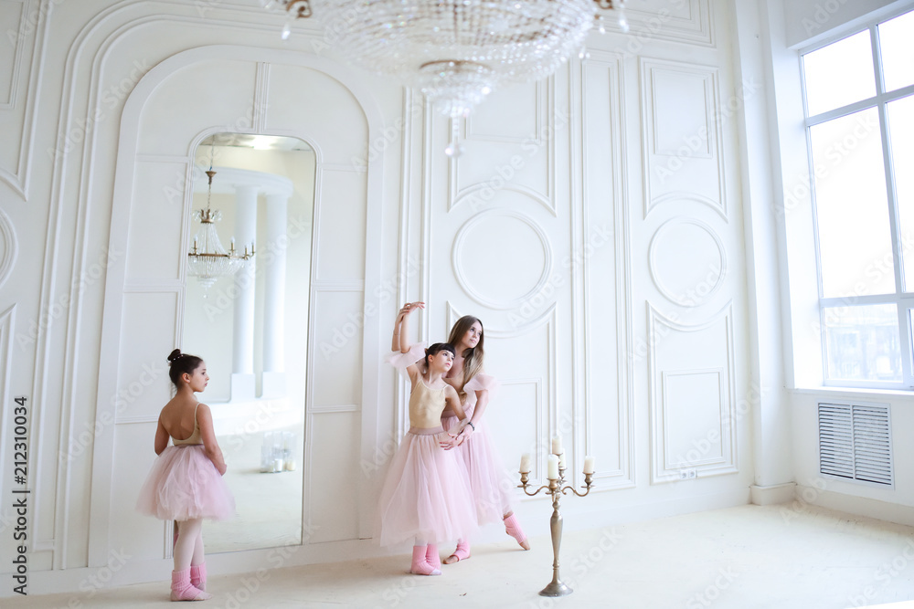 Teacher trains ballet moves with little girls in pink clothes in the room Teacher trains ballet moves with little girls in pink clothes in the room