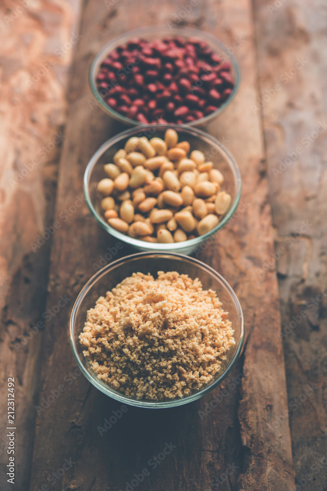 Crushed peanuts or mungfali powder with whole and roasted groundnut. Served in a bowl over moody background. Selective focus Crushed peanuts or mungfali powder with whole and roasted groundnut. Served in a bowl over moody background. Selective focus