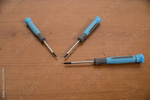 Tools, blue screwdriver on a walnut table