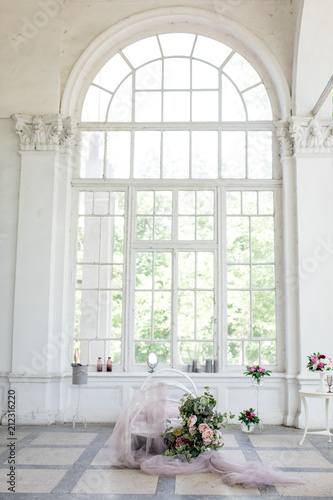 Basket with flowers stands before a panoramic window in the room