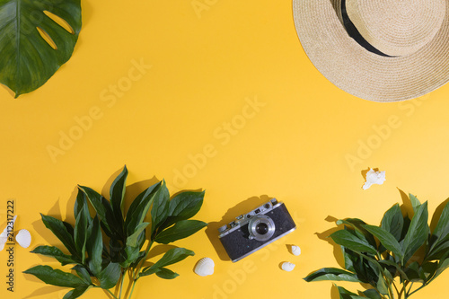 Flat lay design of yellow background with laptop, photo camera, green palm tr...