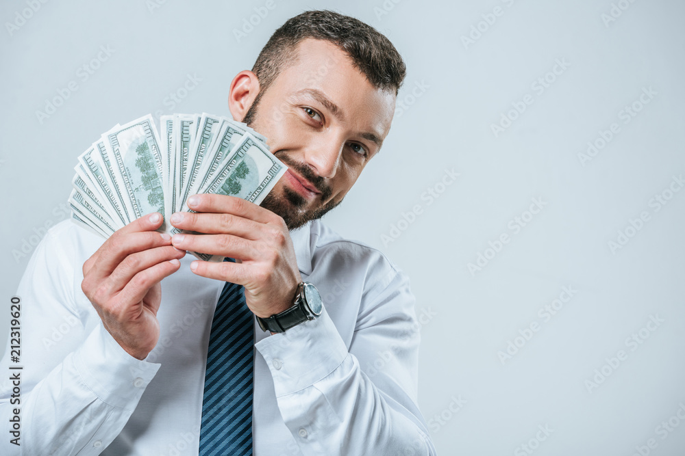 smiling financier showing dollars isolated on grey smiling financier showing dollars isolated on grey