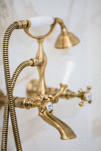 Golden cock in a bathroom made of white marble