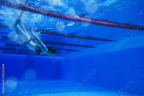 beautiful young girl with a good figure swims under water, effectively dives