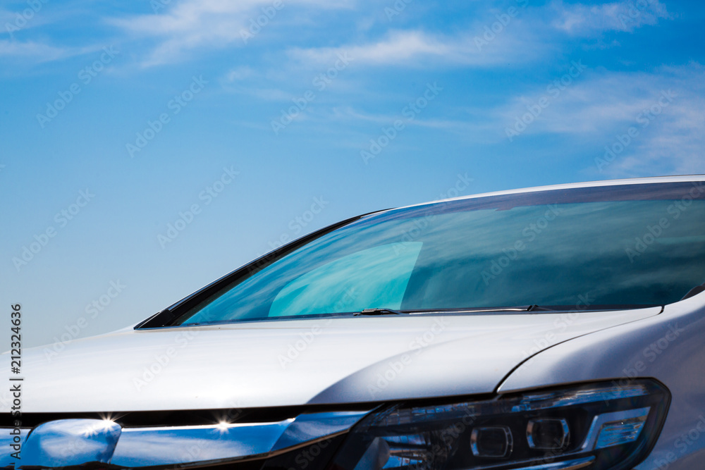 Naklejka premium Close up of a frontside of a car under a cloudy blue sky