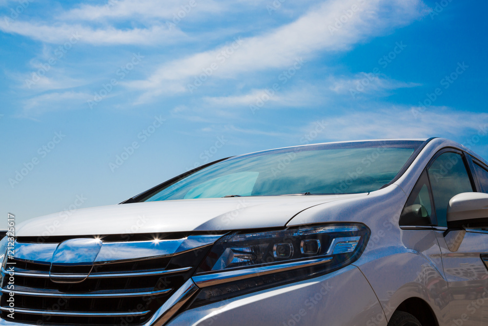 Obraz premium Close up of a frontside of a car under a cloudy blue sky