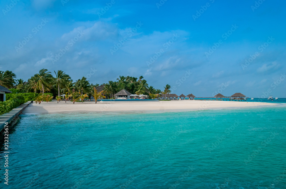 The perfect beach. Beach bungalow. Luxury escape. Tropical paradise. Honeymoon at Maldives. Palms and white sund. Blue ocean	