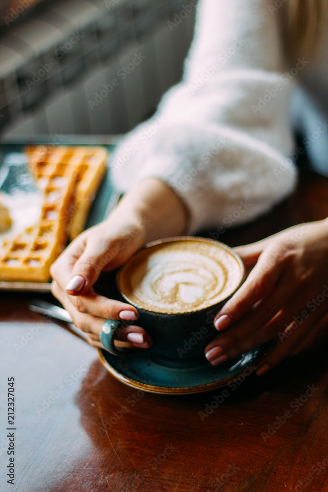 girl at a table in a cafe with a cup of coffee