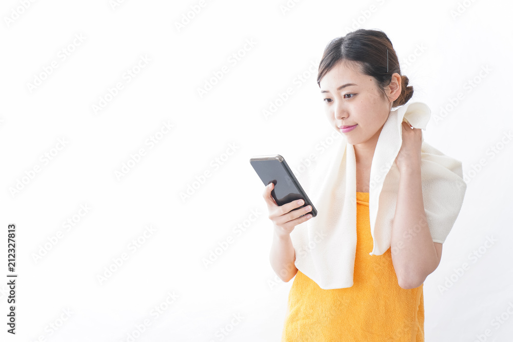 お風呂上がりにスマホをいじる女性 お風呂上がりにスマホをいじる女性