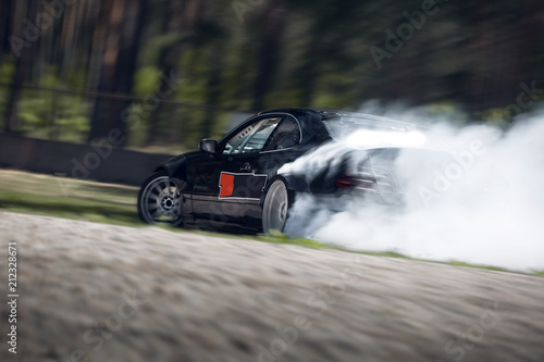 Sport car wheel drifting. Blurred of image diffusion race drift car with lots of smoke from burning tires on speed track © Moose