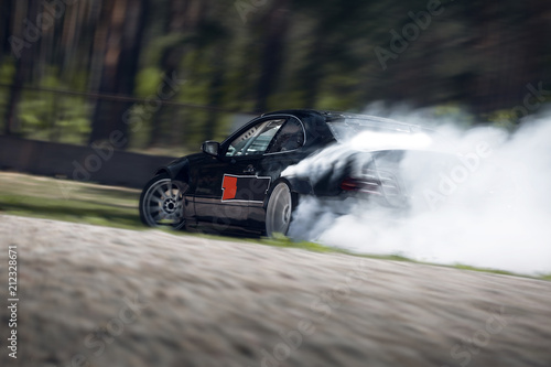 Sport car wheel drifting. Blurred of image diffusion race drift car with lots of smoke from burning tires on speed track