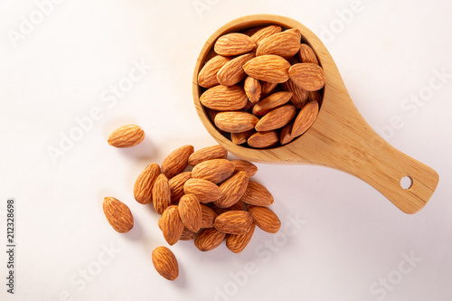 Almond in a wooden cup on a white background.
