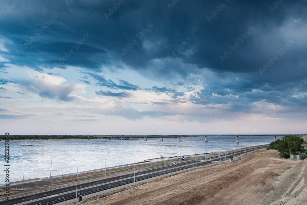  city ​​landscape with a dramatic sky, a view of the river with a bridge, a pre-threat sky