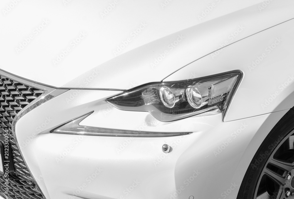 Headlight of a modern white sport car. The front lights of the car. Modern Car exterior details. Car detailing