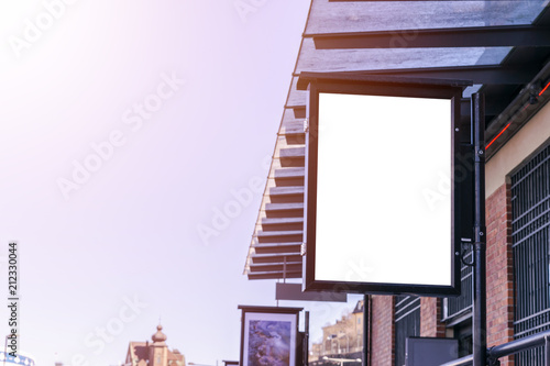 Blank white billboard on city street. In the background street and building. Mock up. Poster on street. Empty space for text. Copy space. Isolated white screen. Mockup for advertising banners.