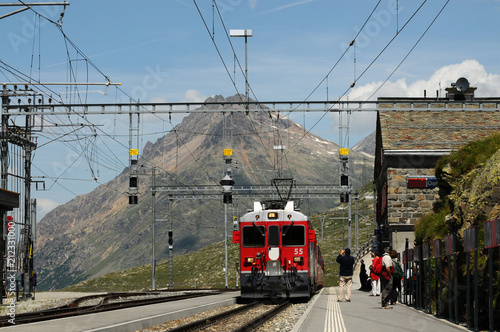 The famous swiss mountain red train Bernina Express arrives from St.Moritz to Ospizio Bernina Station