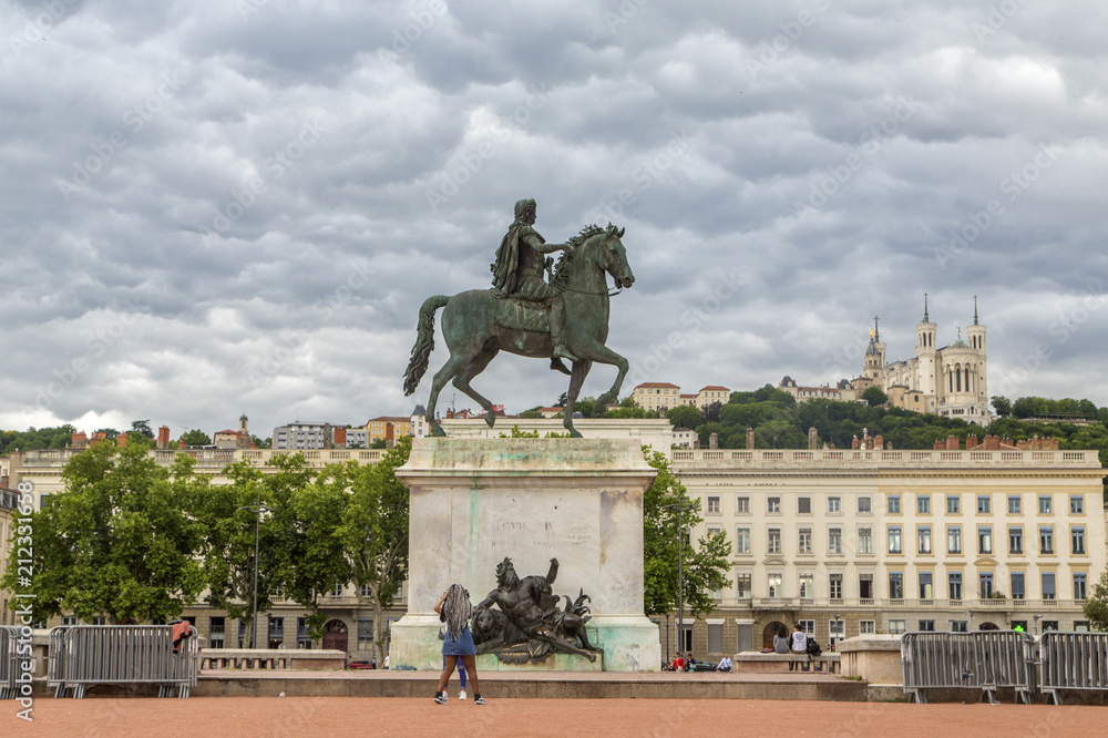 The Bellecour square in Lyon. Statue of Louis and Basilique Fourviere on a background. France
