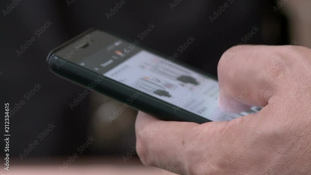 The man flips through his fingers on the touchscreen phone The man flips through his fingers on the touchscreen phone