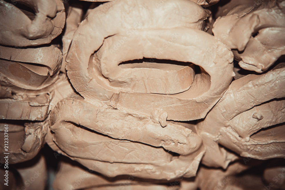 Wet white clay closeup. Abstract pieces of wet clay on the table. Sculptor sculpts pots products from white clay. Dark. Workshop pottery. Master crock. Cultural traditions. Handmade. Craft. Wet white clay closeup. Abstract pieces of wet clay on the table. Sculptor sculpts pots products from white clay. Dark. Workshop pottery. Master crock. Cultural traditions. Handmade. Craft.