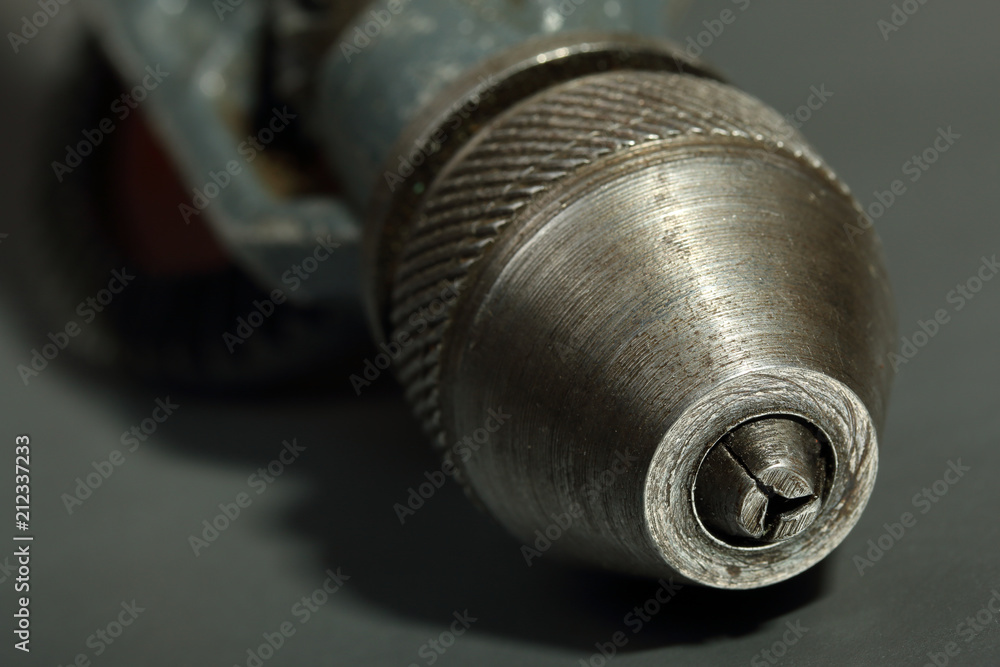 Old drill chuck on a gray background. Details of an old drill Old drill chuck on a gray background. Details of an old drill