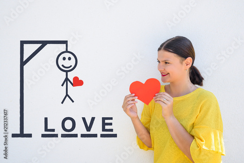 Bild auf Leinwand young woman holds paper heart near hangman traditional game with word love