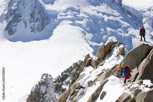 Bergsportler am Gipfel des Dôme du Goûter und strahlend blauer Himmel des Mont-Blanc-Massivs, französische Alpen