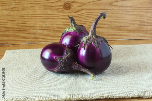 Whole fresh eggplant or aubergine bringal in wooden background photo