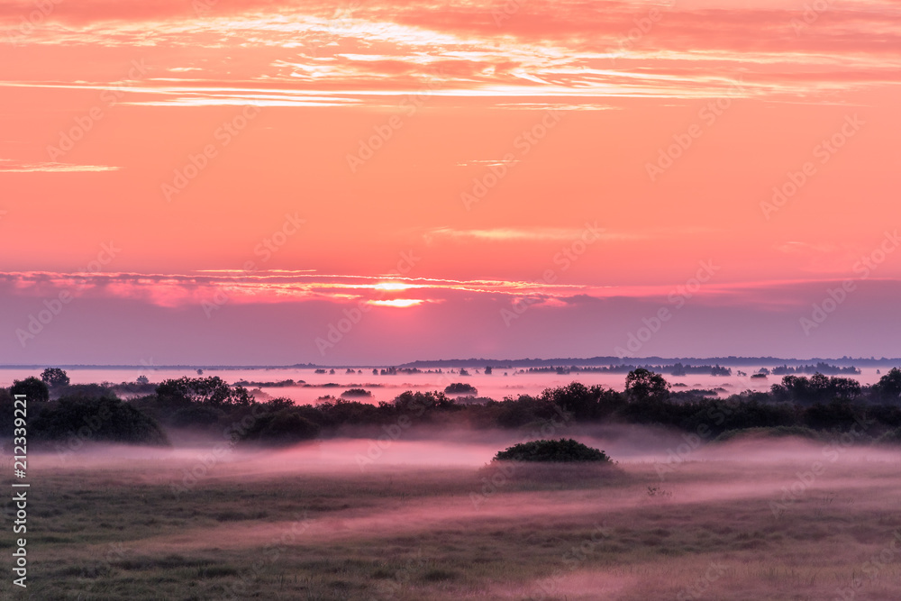 Colorful landscape with fog over the fields during sunrise.