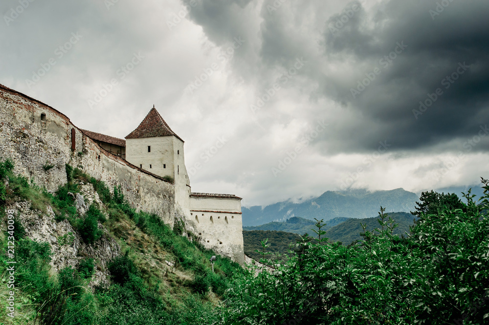 Ryshnov fortress against the backdrop of the mountains and the cloudy sky.