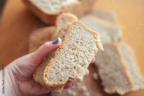 slices of home bread in hands on a wooden cutting board
