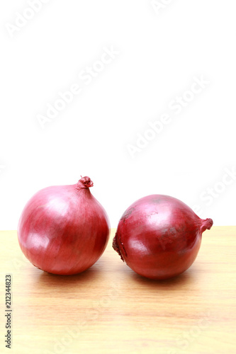 Two red onion on wooden top