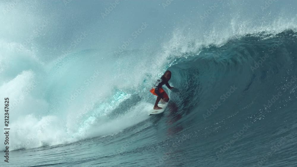 SLOW MOTION, CLOSE UP: Glassy ocean water splashes over experienced surfer riding a big tube wave. Stunning shot of extreme rider challenging himself to ride the inside of a large hollow barrel wave. SLOW MOTION, CLOSE UP: Glassy ocean water splashes over experienced surfer riding a big tube wave. Stunning shot of extreme rider challenging himself to ride the inside of a large hollow barrel wave.