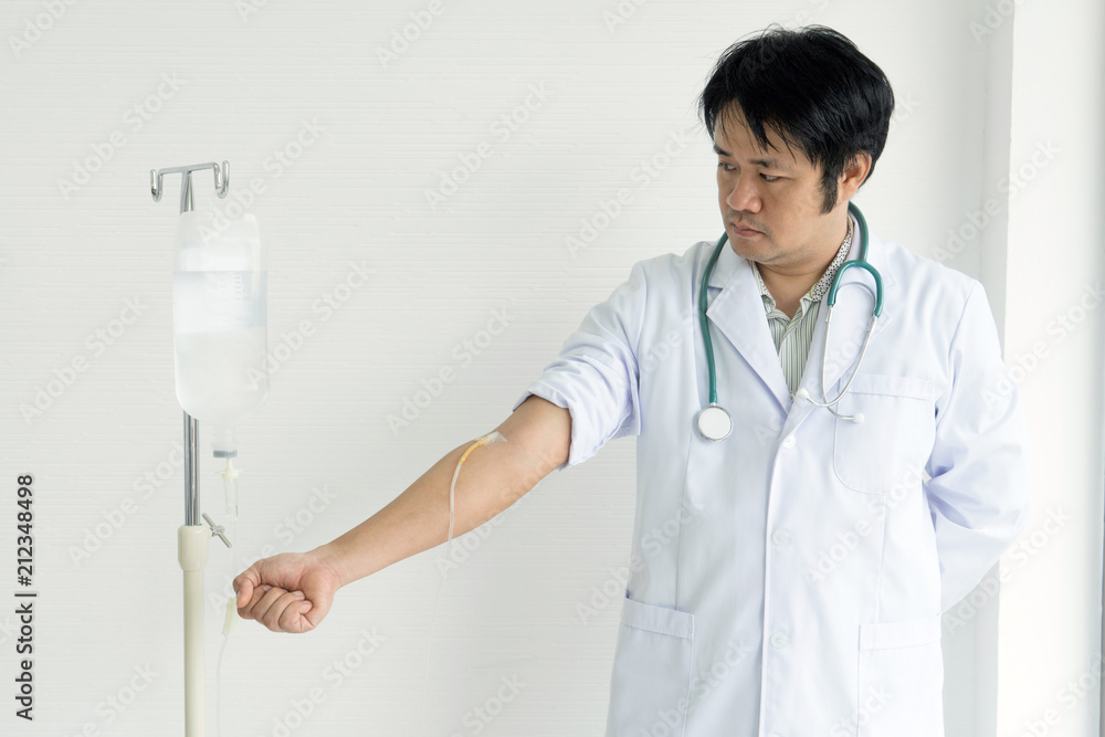 Asian male doctor showing and demonstrate how to infusion drip in doctor class by infusion drip himself on his hand. Asian male doctor showing and demonstrate how to infusion drip in doctor class by infusion drip himself on his hand.