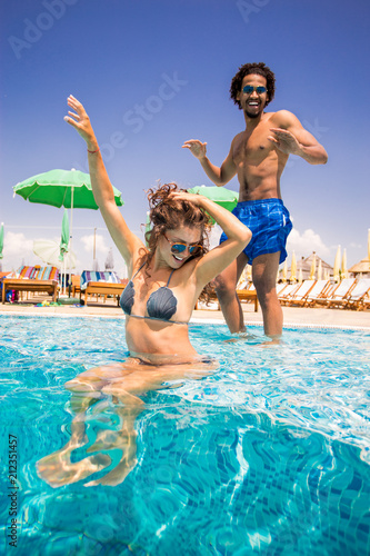 Happy young couple enjoying a sunny day at the pool