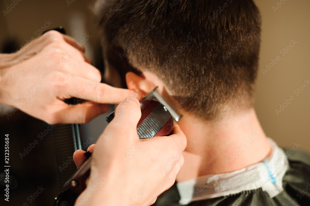 Master cuts hair and beard of men in the barbershop Master cuts hair and beard of men in the barbershop