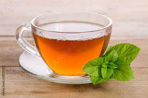Glass cup of Tea with mint leaves on wooden table