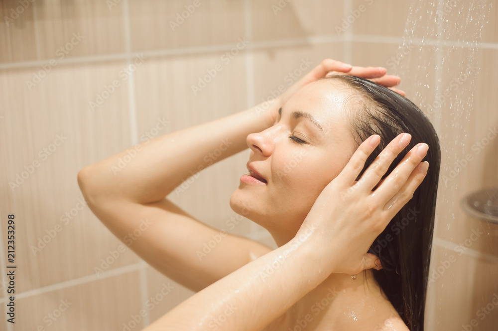 Naklejka premium Woman with long hair taking shower.