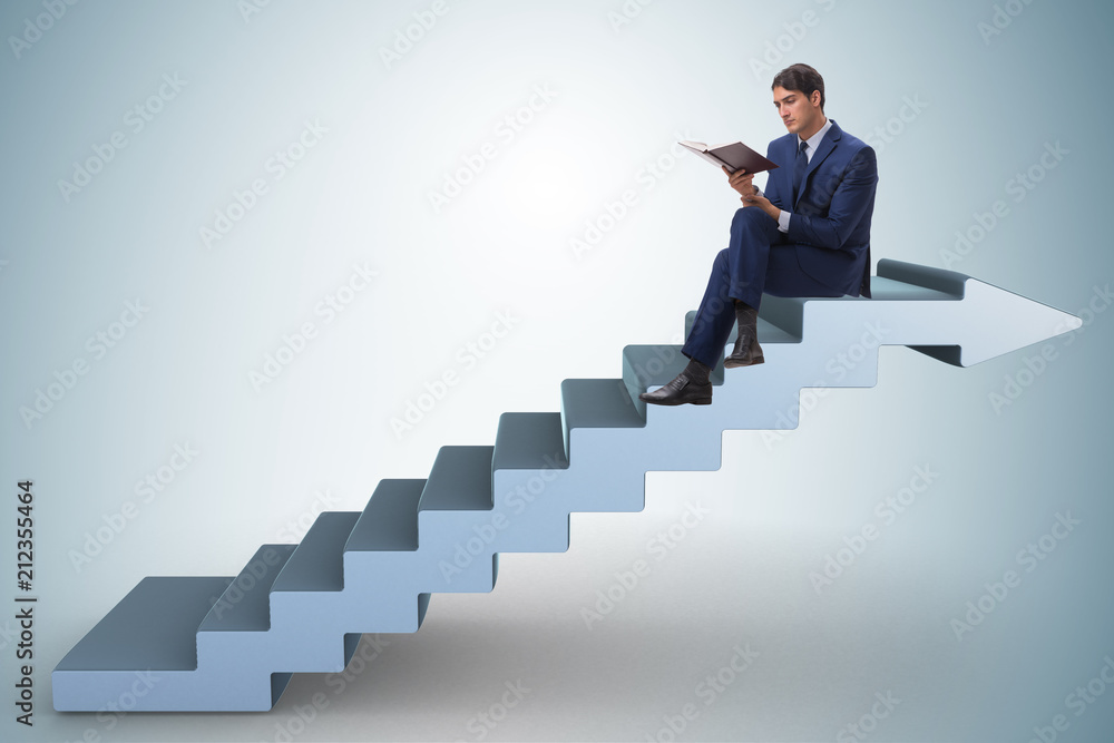 Businessman in career ladder concept reading book Businessman in career ladder concept reading book