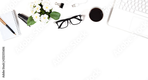 Office table with a computer, a notebook, glasses, a stapler and a cup of coffee