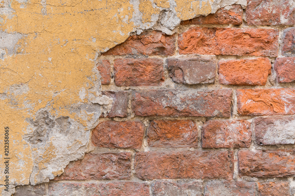 Obraz premium Old damaged brick wall with plaster.